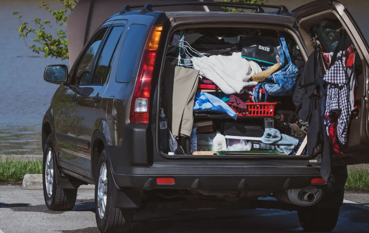 A cluttered SUV. Photo Courtesy of Pexels: https://www.pexels.com/photo/elderly-person-sitting-on-chair-next-to-car-12137012/